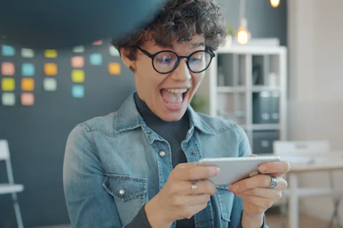 Excited young woman playing a game on her smartphone